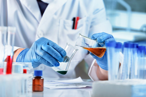 Chemist handling flasks in a laboratory