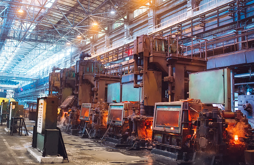 Steel mill processing line with glowing furnaces